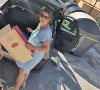 Petra, eigenaresse van Consells, bij achterklep auto waar ze spullen uitlaadt bij vuilcontainer