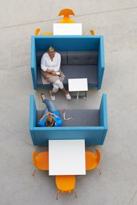 Overlegplek op kantoor bestaand uit twee blauwgeverfde zitbanken die tegenover elkaar zijn opgesteld